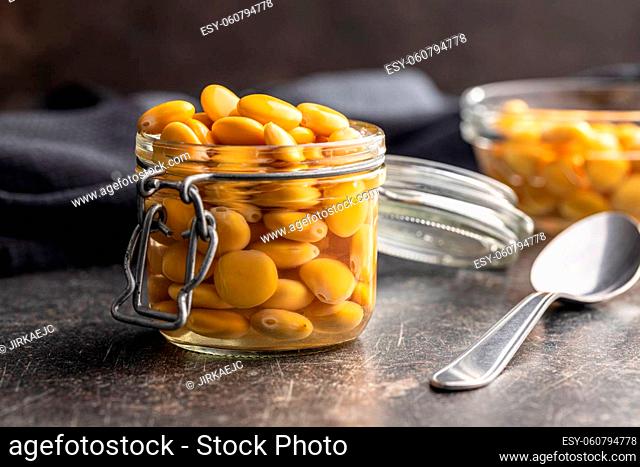 Pickled yellow Lupin Beans in jar on kitchen table