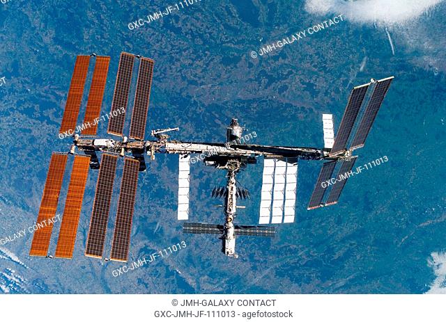 Backdropped by a colorful Earth, the International Space Station is seen from Space Shuttle Discovery as the two spacecraft begin their relative separation