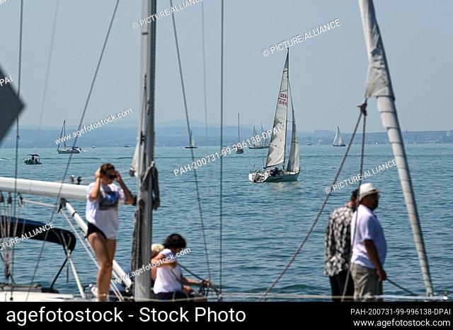 31 July 2020, Baden-Wuerttemberg, Gohren Am Bodensee: Several sailing boats sail off Gohren on Lake Constance. More than 32 degrees Celsium is indicated by the...