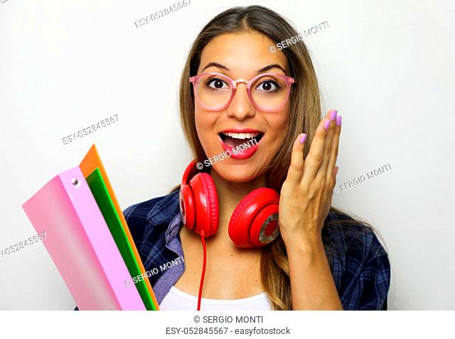 Back to school concept. Image of surprised emotive young woman wears glasses and checkered shirt stands on white background