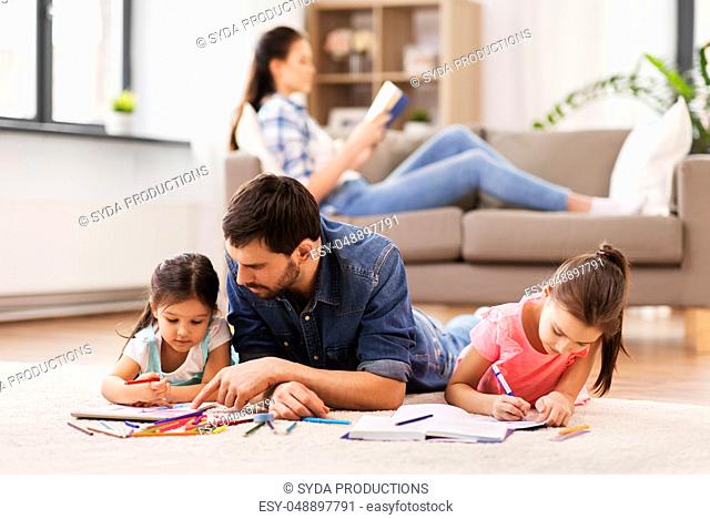 father with little daughters drawing at home