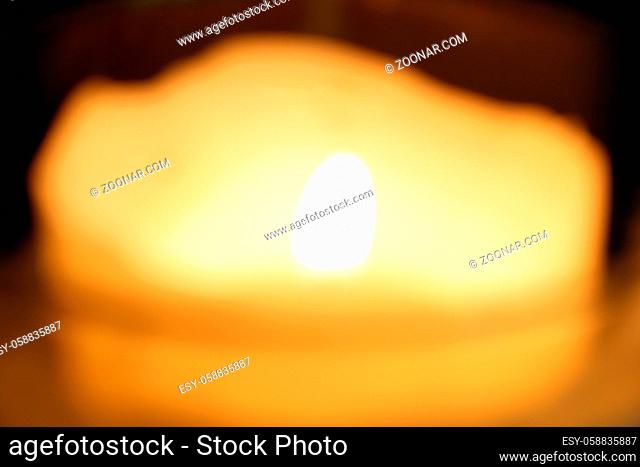 Burning candle on dark background.Out of focus. Symbol of sorrow