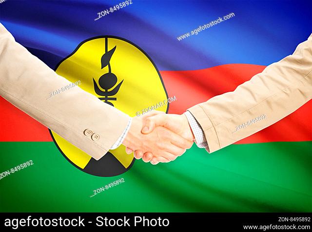 Businessmen shaking hands with flag on background - New Caledonia