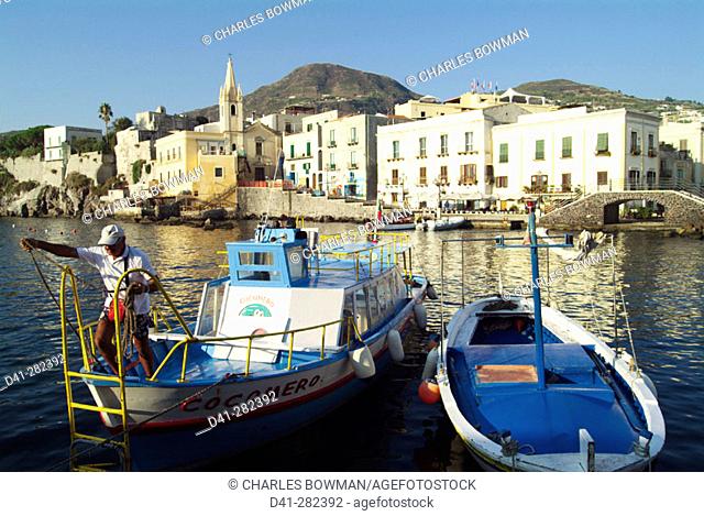 Boatman mooring a boat. Port. Lipari. Aeolian Islands. Sicily. Italy
