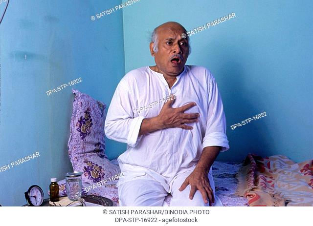 indian sick old man clutching his chest with pain MR#556