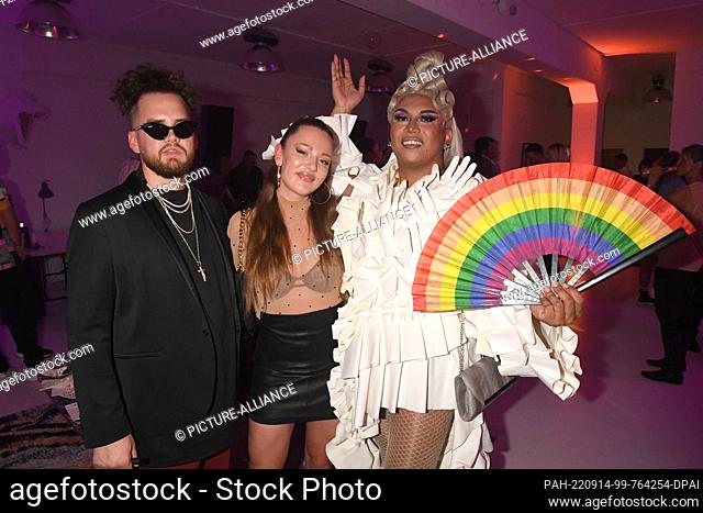 14 September 2022, Bavaria, Munich: Joelina Drews (m) and her boyfriend Adrian Louis (l) show off with Pinay Colada at the opening of Average Sucks' new loft...