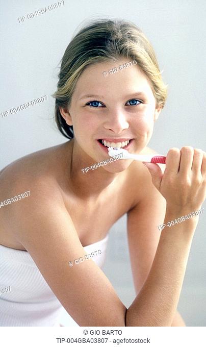 Woman's portrait brushing teeth