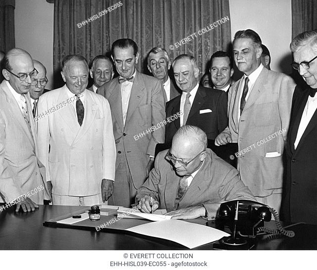 President Eisenhower signs H.R. 1 in the Cabinet Room. June 21, 1955. The law extended the authority of the President to enter into trade agreements under the...