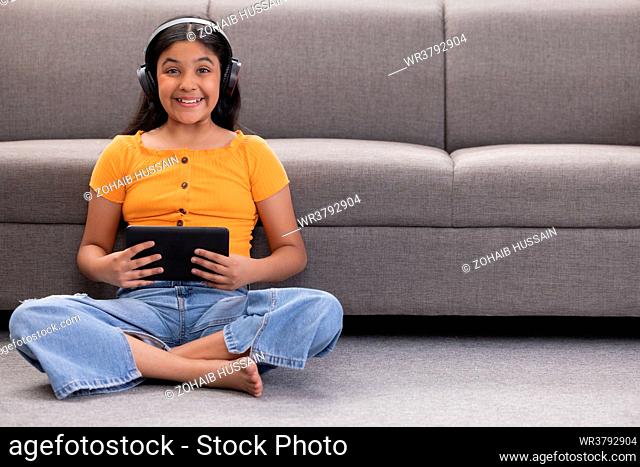 Portrait of a cheerful girl listening to music at home