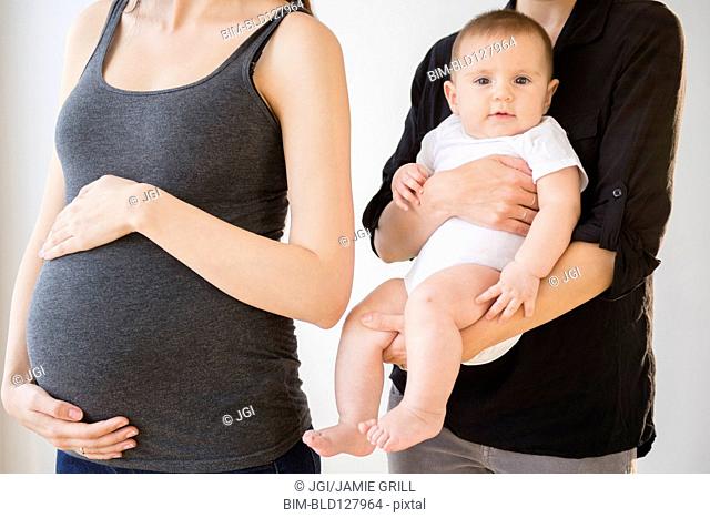 Pregnant Caucasian woman with friend and baby
