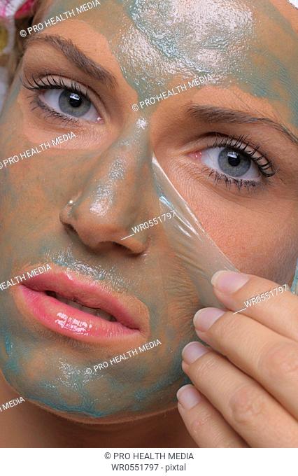 Young woman removes the face mask