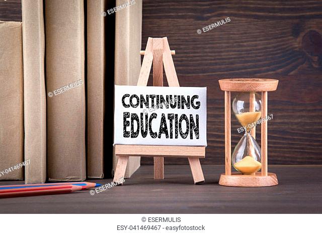 Continuing Education concept. Sandglass, hourglass or egg timer on wooden table showing the last second or last minute or time out