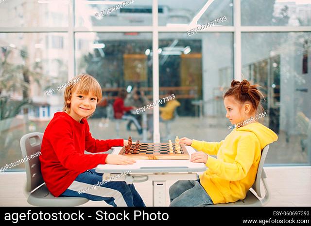 Little kids playing chess at kindergarten or elementary school