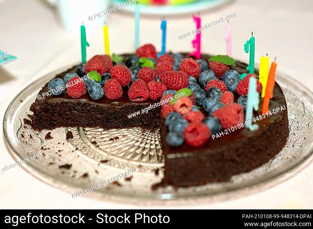 12 December 2020, Saxony-Anhalt, Magdeburg: On a table is a chocolate birthday cake with raspberries, blueberries and ten candles