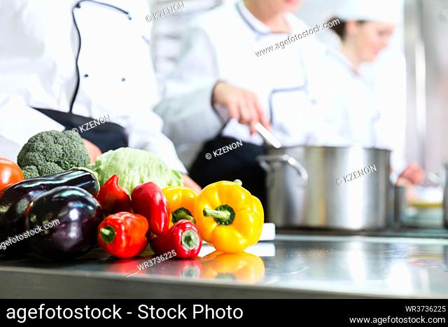 Team of chefs preparing food in canteen kitchen