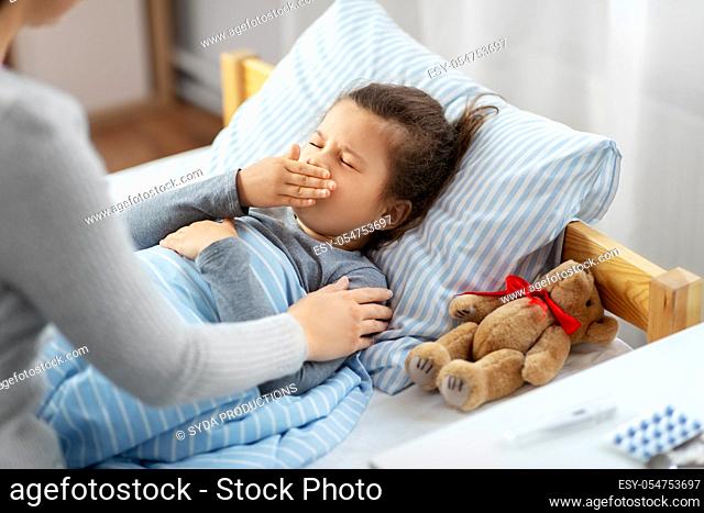 mother and sick little daughter in bed at home