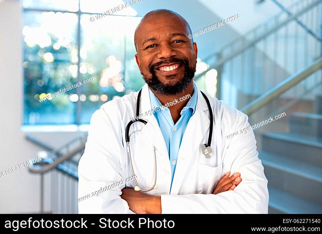 Portrait of smiling african american male doctor in hospital corridor
