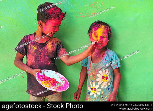 SYLHET, BANGLADESH - MARCH 23, 2022: Bangladesh children from Khan Tea garden posing for photos painted after adorning with colors like Rainbows on the...