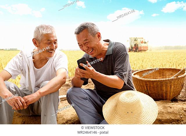 Two farmers sitting in field talking