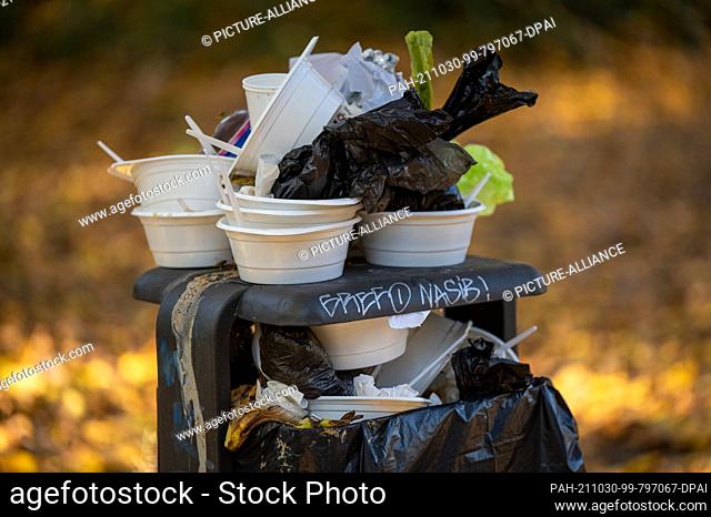 29 October 2021, Berlin: Used disposable containers and plates pile up on an overflowing trash can in a park. Photo: Monika Skolimowska/dpa-Zentralbild/dpa