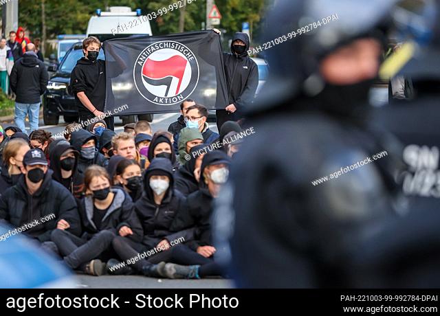 03 October 2022, Saxony, Leipzig: Left-wing counter-demonstrators from the alliance ""Leipzig nimmt Platz"" (Leipzig takes a seat) block a demonstration ""Für...