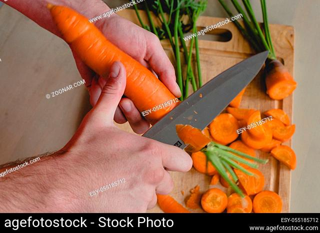 Food, natural. Guy cuts carrot