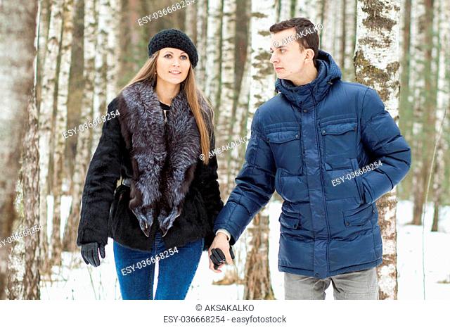 Happy Young Couple in Winter birchwood walking