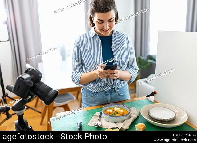 food blogger with smartphone working in kitchen