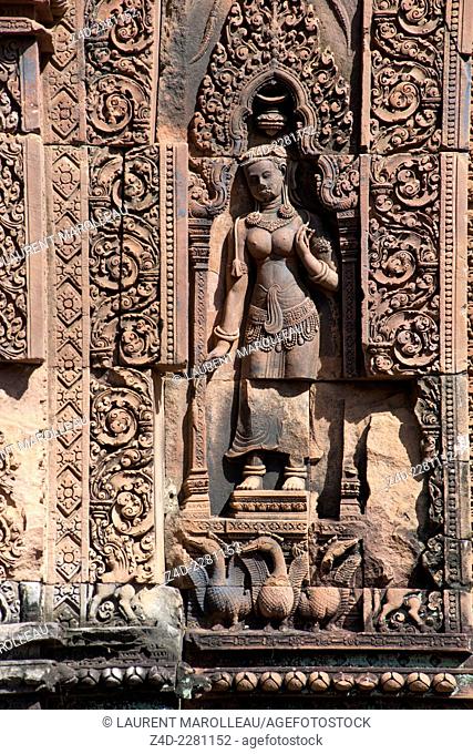 Devata carved into the red sandstone wall. Banteay Srei (citadel of the women or citadel of beauty) temple dedicated to the Hindu god Shiva