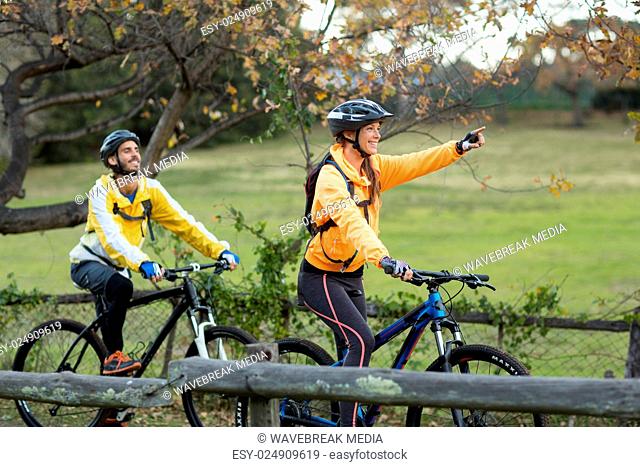 Biker couple cycling and pointing in distance