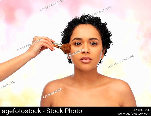 woman and hand of make up artist with brush