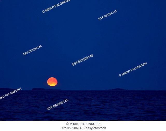 Moonrise over Baltic Sea in Southern Finland on early summer night in August
