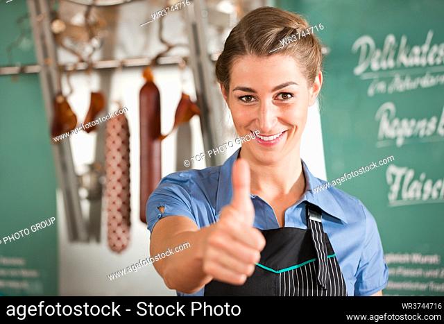 Portrait of butcher showing thumbs up at butchery