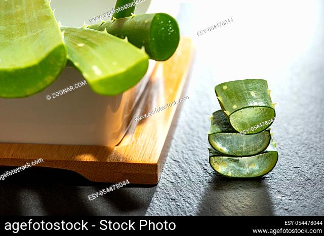 Aloe vera slices on dark background. Health and beauty concept. Closeup aloe pieces on backlight