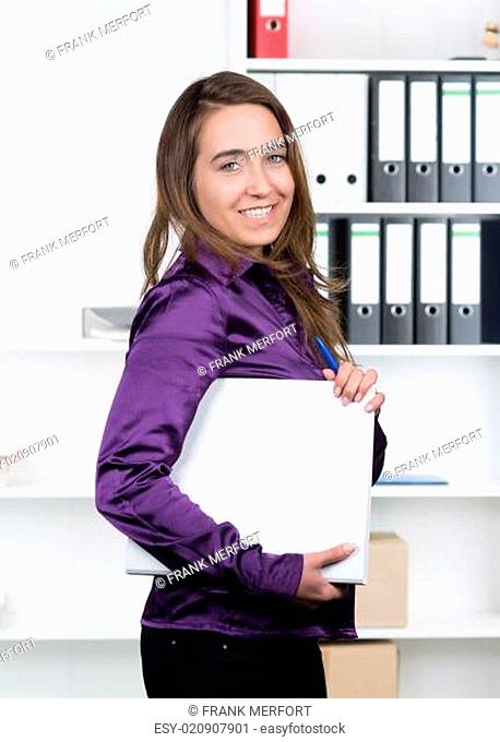 Frau hält einen Aktenordner im Büro