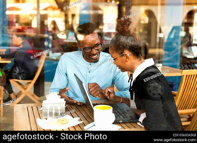Black African American coworkers doing digital teamwork arround a coffee cup