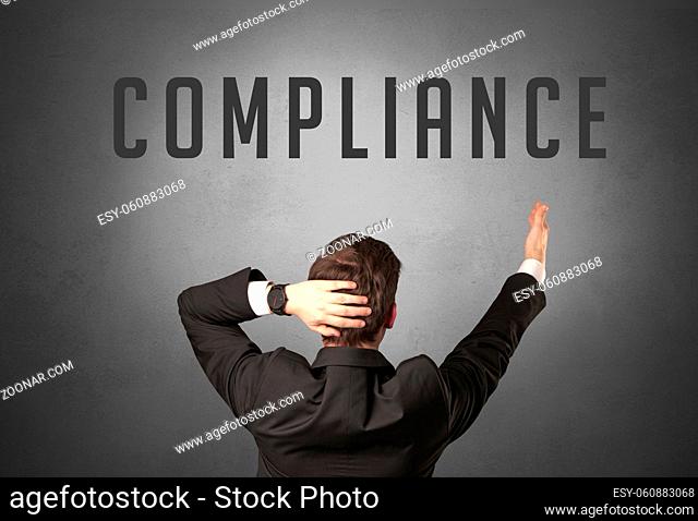 Rear view of a businessman with COMPLIANCE inscription, powerfull business concept