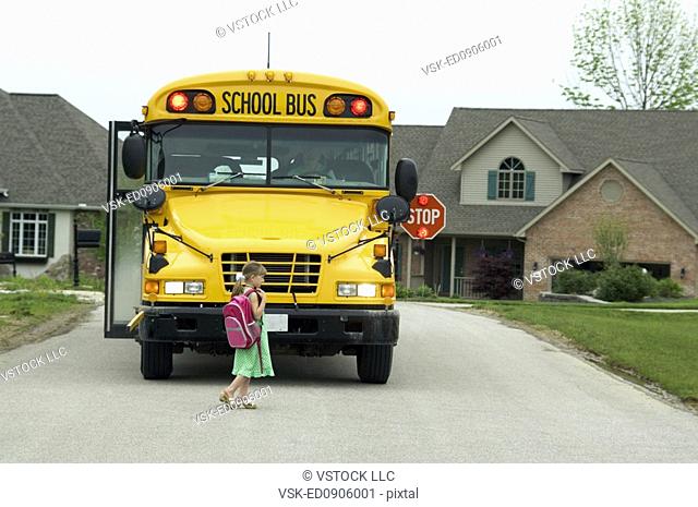 Girl getting on school bus