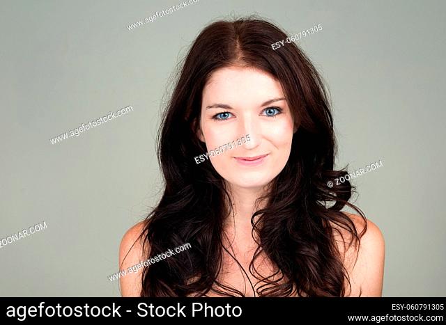 Studio shot of young beautiful woman with wavy hair against white background