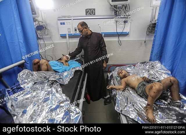 11 October 2023, Palestinian Territories, Gaza City: Palestinian children lie on the beds of Al-Shifa Hospital, after sustaining severe injuries as a result of...