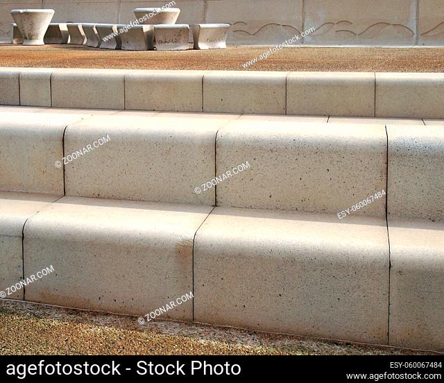 modern angled outdoor steps with rounded corners in textured grey and brown colors with concrete seating