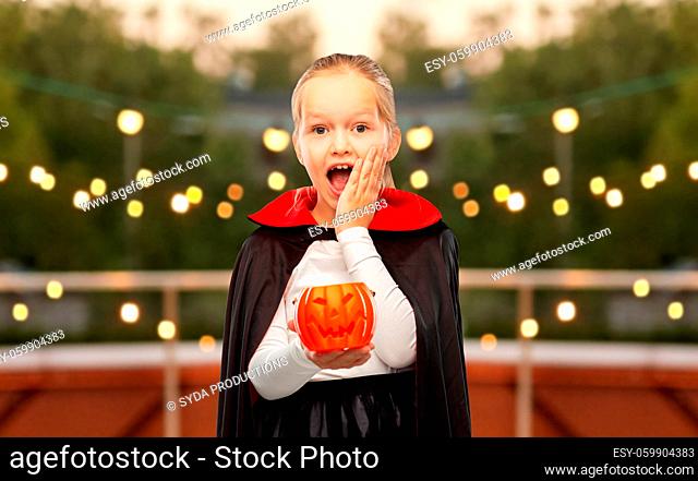 girl in halloween costume of dracula with pumpkin