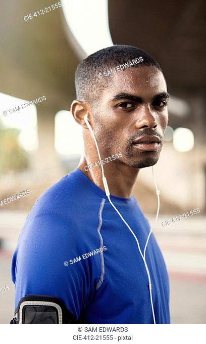 Man with headphones exercising on city street