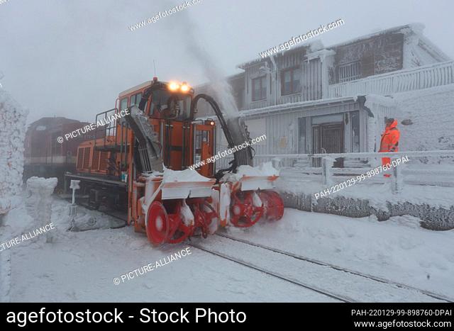 29 January 2022, Saxony-Anhalt, Schierke: A snow blower of the Harzer Schmalspurbahn clears the snow from the tracks on the Brocken in foggy weather