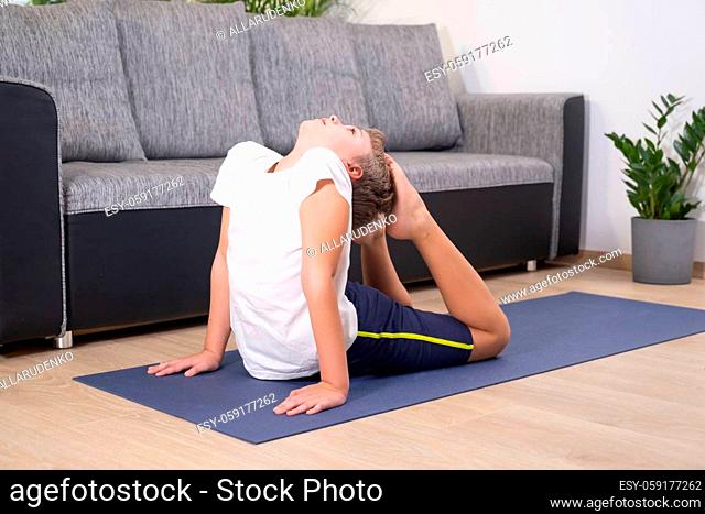 Blond boy goes in for sports on yoga mat. Child physical activity. Sport healhty lifestyle active leisure at home during COVID-19 quarantine