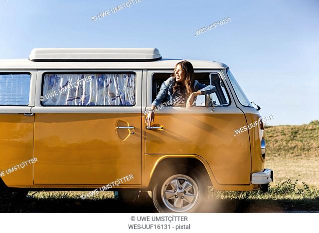Pretty woman on a road trip with her camper, looking out of car window
