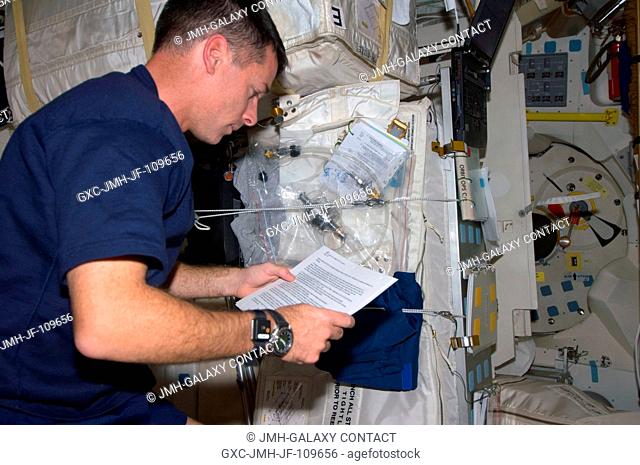 Astronaut Shane Kimbrough, STS-126 mission specialist, reads a procedures document on the middeck of Space Shuttle Endeavour while docked with the International...