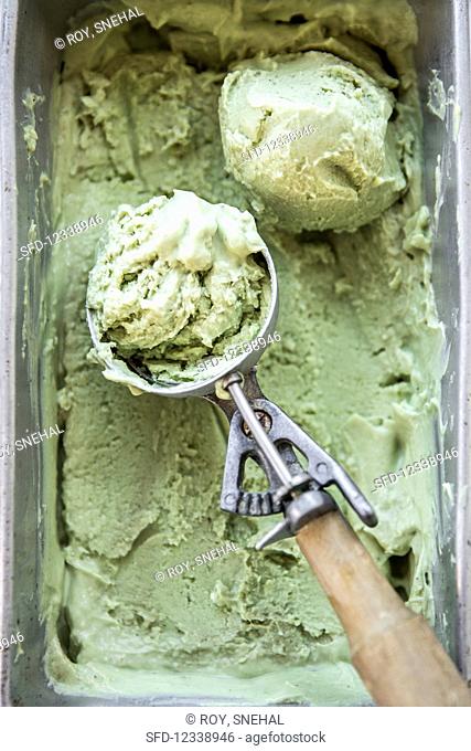 Avocado-Matcha ice cream in an ice-cream container with ice-cream cone