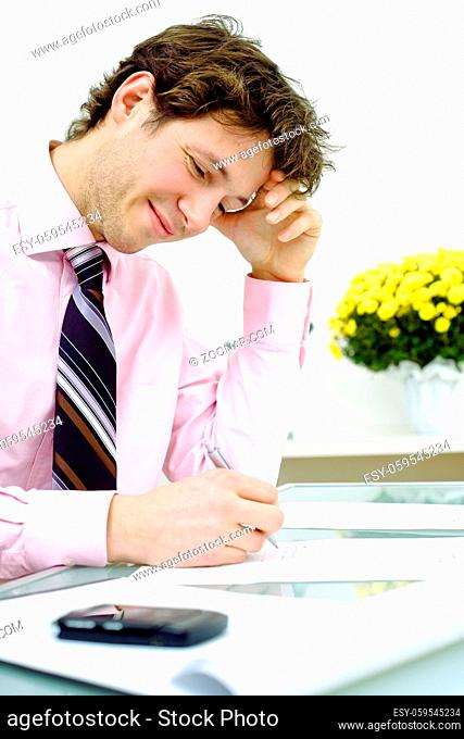 Young businessman working in office, smiling. Vertical version