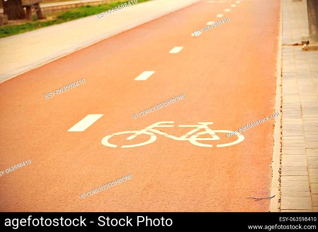 Downtown empty red bicycle track with painted bicycle sign